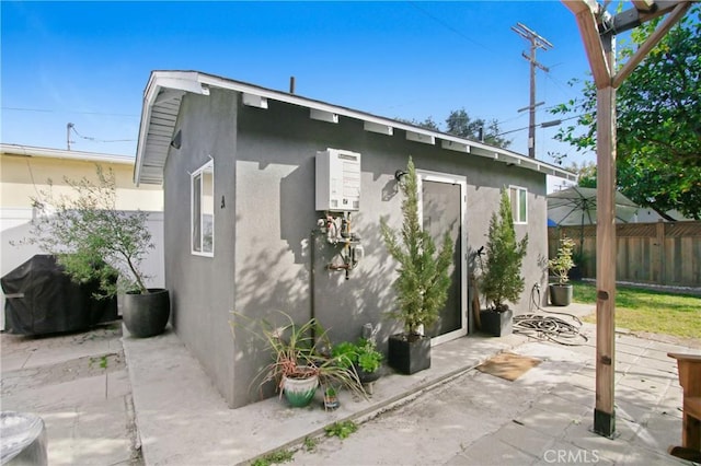 exterior space with water heater and a patio