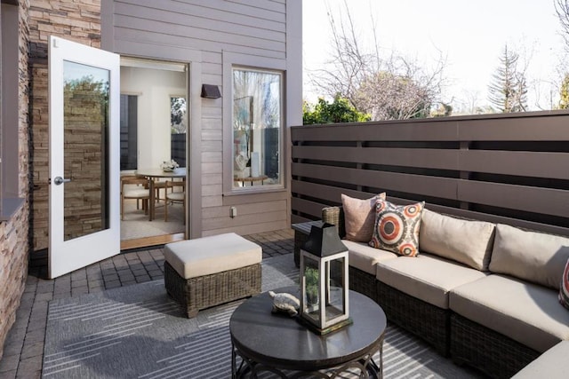 wooden terrace featuring outdoor lounge area and a patio