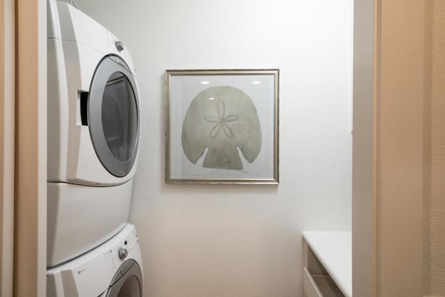 washroom featuring stacked washer / drying machine