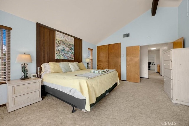 carpeted bedroom with beamed ceiling, high vaulted ceiling, and a closet