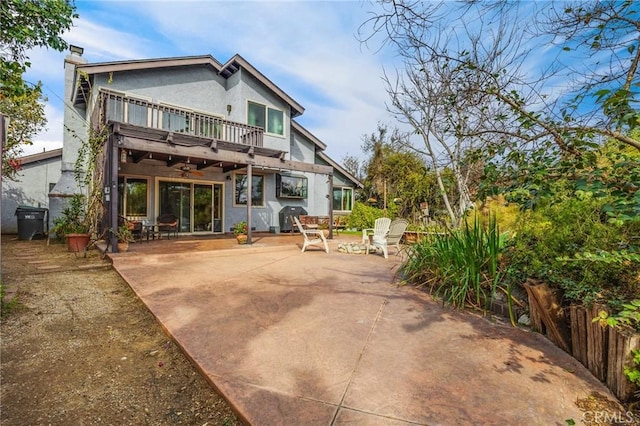 rear view of property featuring a balcony and a patio area