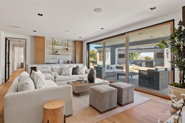 living room featuring indoor bar and light hardwood / wood-style flooring