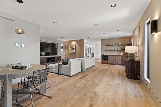 living room with bar and light wood-type flooring