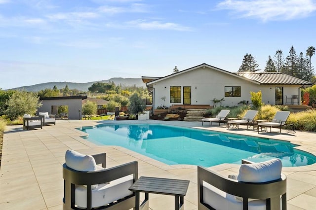 view of swimming pool featuring a mountain view and a patio