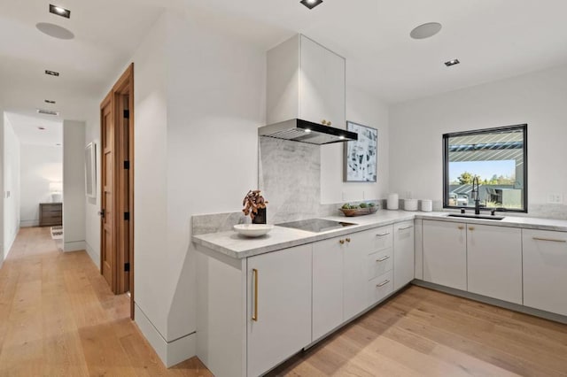 kitchen with extractor fan, white cabinetry, sink, black electric cooktop, and light wood-type flooring