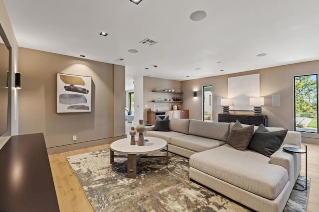 living room with bar and light hardwood / wood-style floors