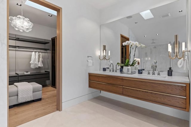 bathroom with vanity, wood-type flooring, and a skylight