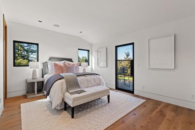 bedroom with lofted ceiling, light hardwood / wood-style flooring, and access to outside