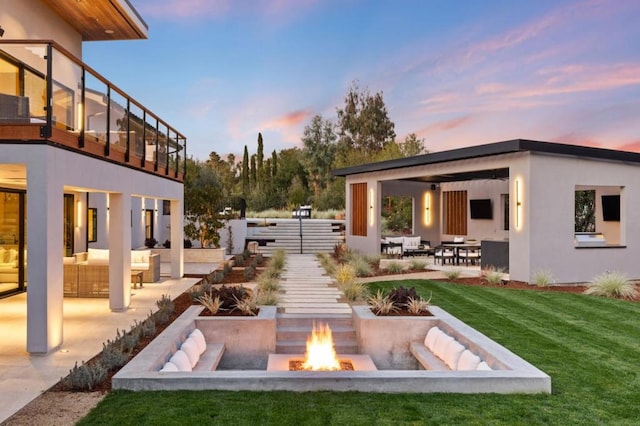 yard at dusk with a fire pit and a patio area