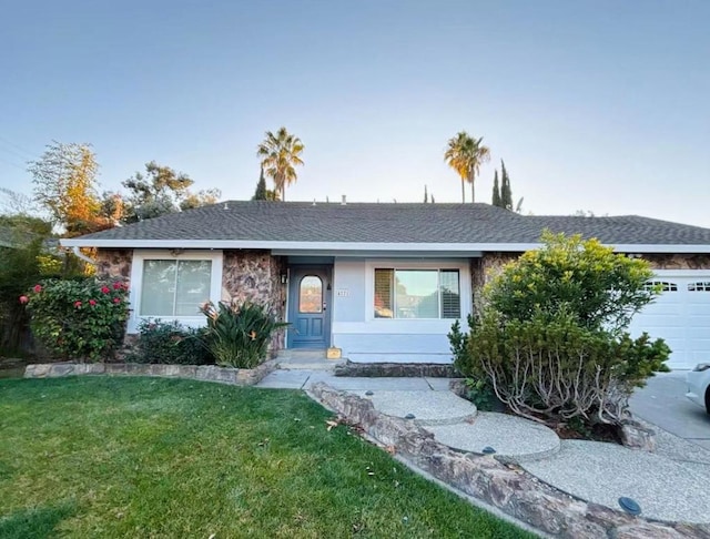 single story home featuring a garage and a front yard