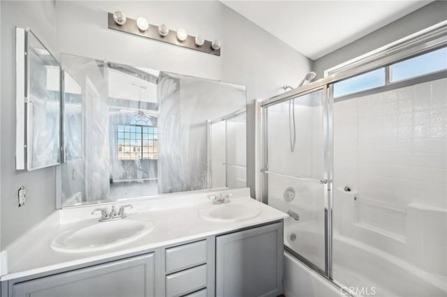 bathroom with vanity, a wealth of natural light, and bath / shower combo with glass door