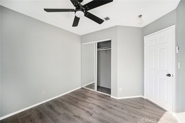 unfurnished bedroom featuring hardwood / wood-style floors, ceiling fan, and a closet