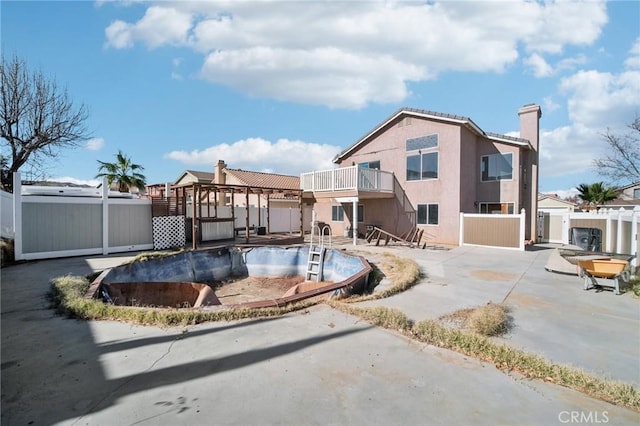 rear view of house with a jacuzzi, a patio area, and a balcony