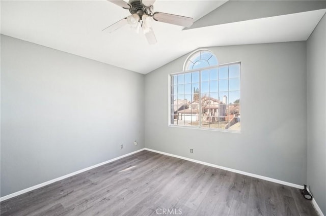 empty room featuring lofted ceiling, dark wood-type flooring, and ceiling fan