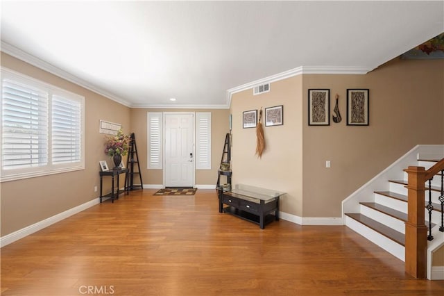 foyer with crown molding and light hardwood / wood-style floors