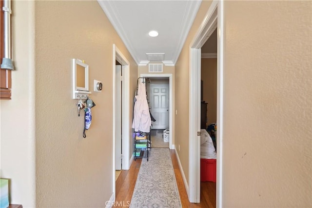 corridor featuring crown molding and light wood-type flooring