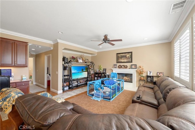 living room with ceiling fan, ornamental molding, and built in desk