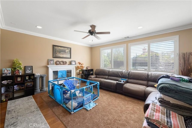 living room featuring hardwood / wood-style flooring, crown molding, and ceiling fan