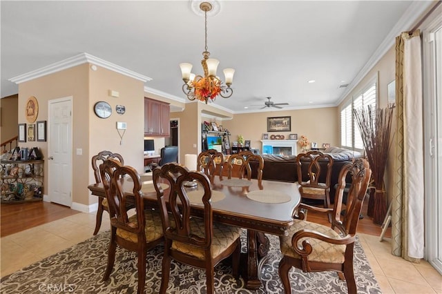 dining space with light tile patterned floors, ceiling fan with notable chandelier, and ornamental molding