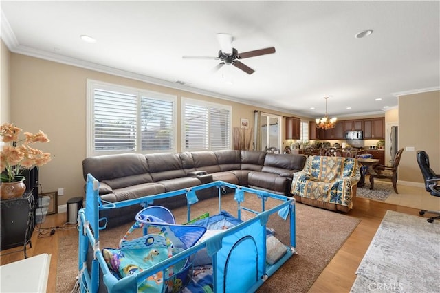 living room featuring ornamental molding, ceiling fan with notable chandelier, and light wood-type flooring