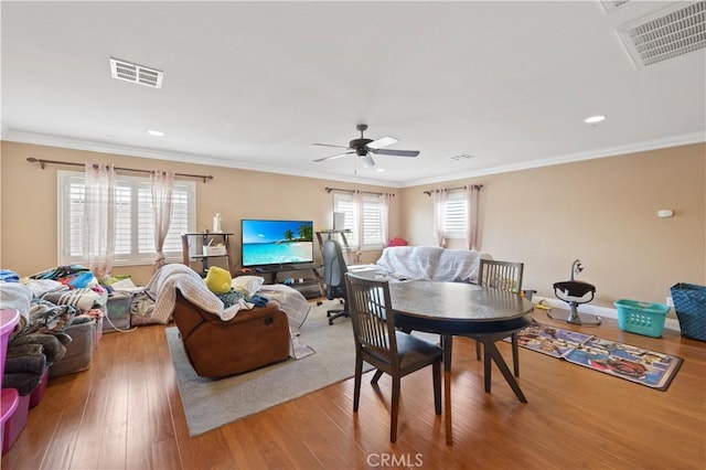 living room featuring hardwood / wood-style flooring, crown molding, and ceiling fan