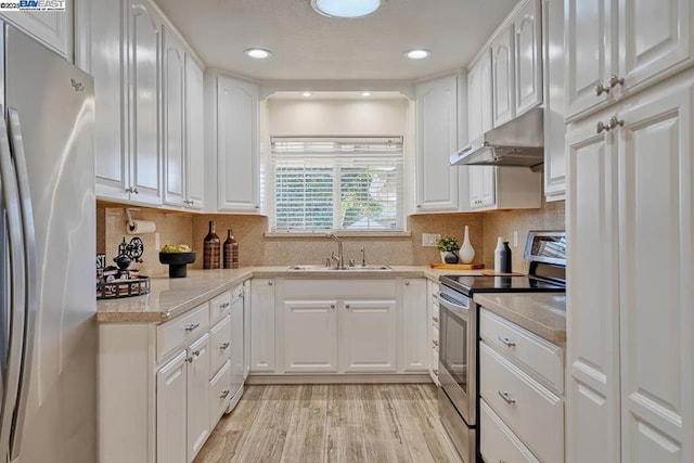 kitchen with white cabinetry, sink, stainless steel appliances, and light hardwood / wood-style floors