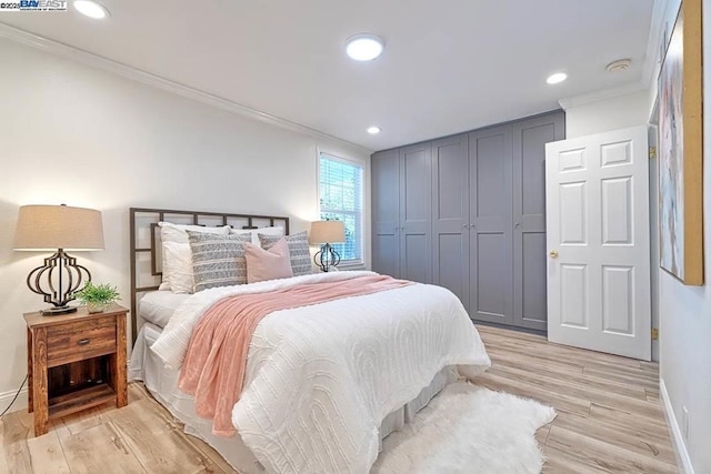 bedroom with crown molding, a closet, and light hardwood / wood-style flooring