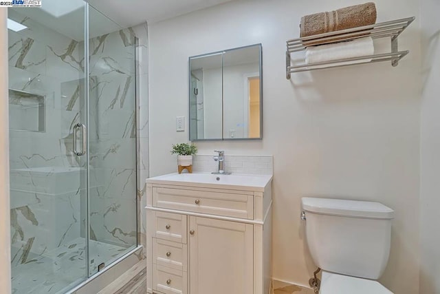 bathroom with vanity, a shower with shower door, tasteful backsplash, and toilet