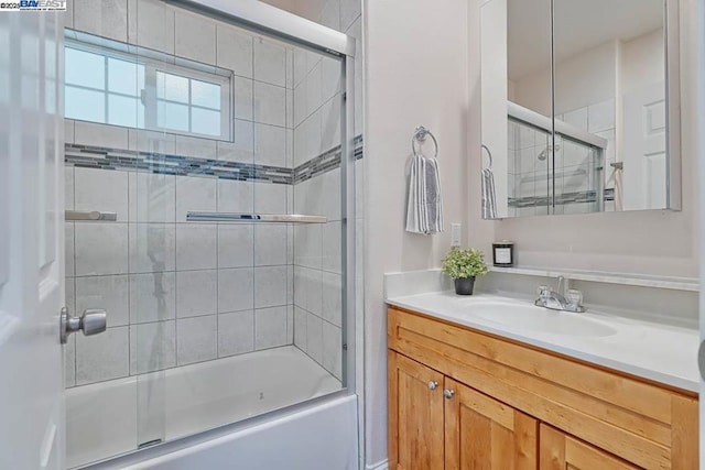 bathroom with vanity and shower / bath combination with glass door