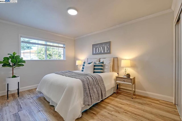 bedroom featuring crown molding and light hardwood / wood-style floors