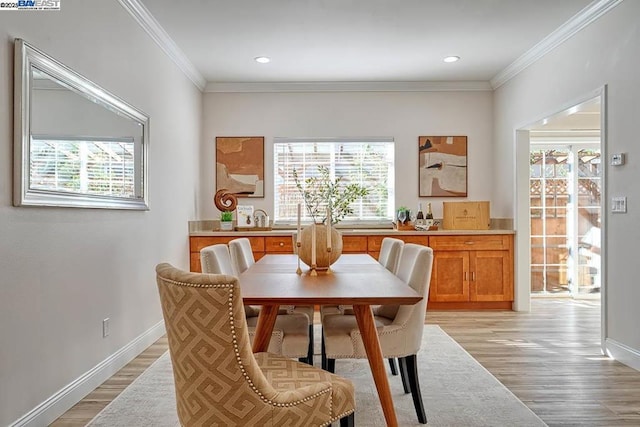 dining room featuring light hardwood / wood-style flooring and ornamental molding