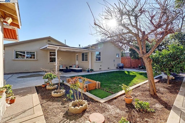 rear view of property featuring a lawn and a patio area