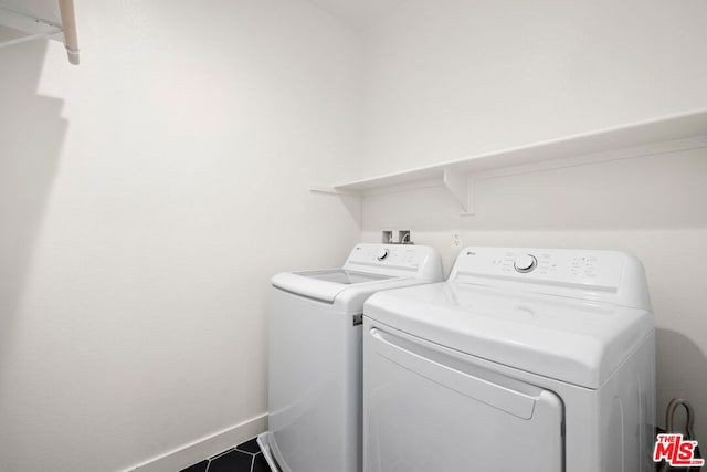 washroom with tile patterned flooring and washing machine and dryer