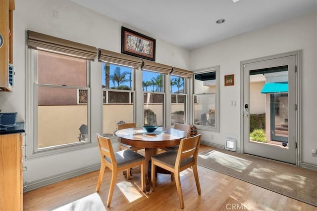 dining space featuring light wood-style floors and baseboards