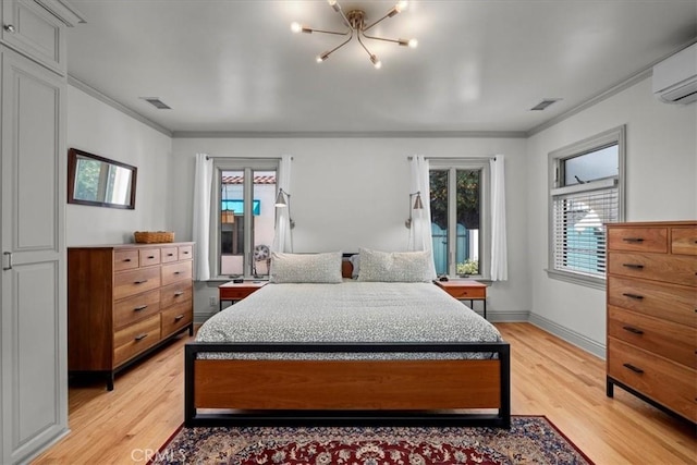 bedroom with light wood-style floors, visible vents, ornamental molding, and a wall mounted AC