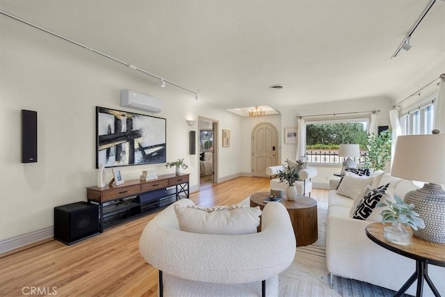 243 Park Ave, Long Beach, CA 90803 - living area featuring track lighting, light wood finished floors, a wall unit AC, and baseboards