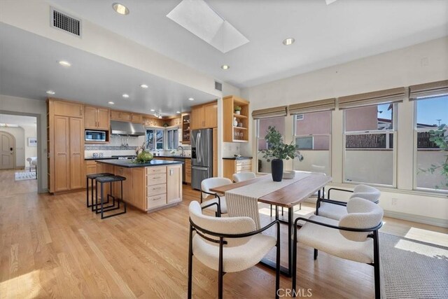 243 Park Ave, Long Beach, CA 90803 - kitchen featuring stainless steel appliances, under cabinet range hood, a skylight, a center island, and recessed lighting
