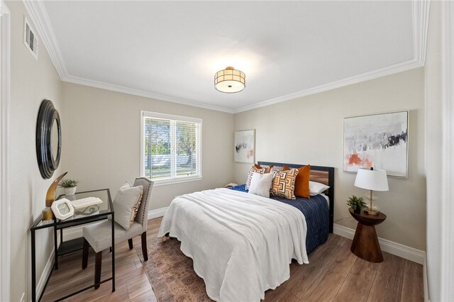 bedroom featuring ornamental molding and hardwood / wood-style floors