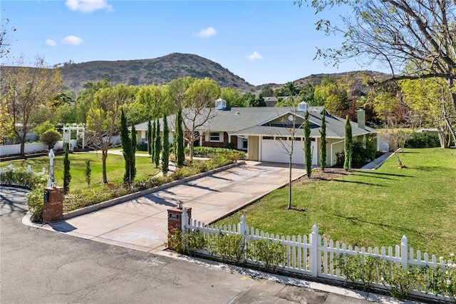 ranch-style house featuring a garage, a mountain view, and a front yard