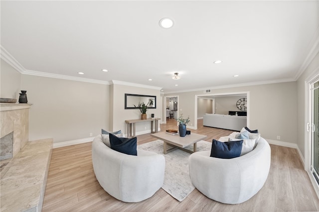 living room with crown molding, a premium fireplace, and light wood-type flooring