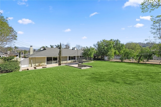 rear view of property featuring a patio area and a lawn