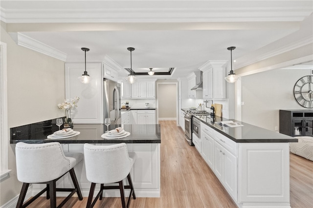 kitchen with white cabinetry, hanging light fixtures, kitchen peninsula, and appliances with stainless steel finishes