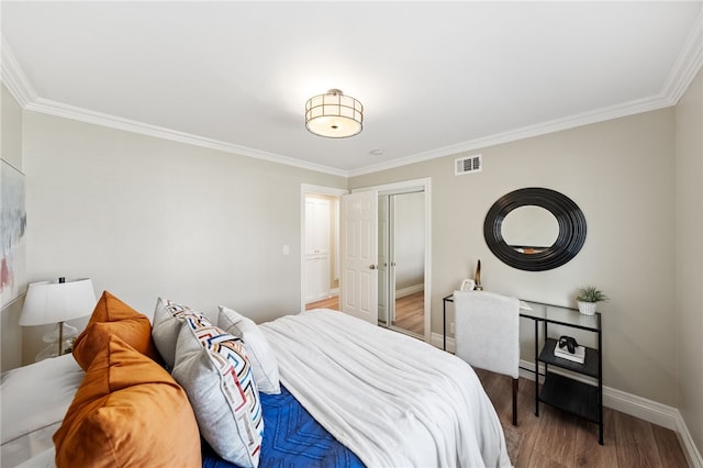 bedroom featuring wood-type flooring, ornamental molding, and a closet