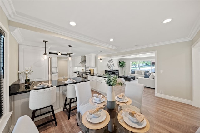 dining room with crown molding and light hardwood / wood-style flooring