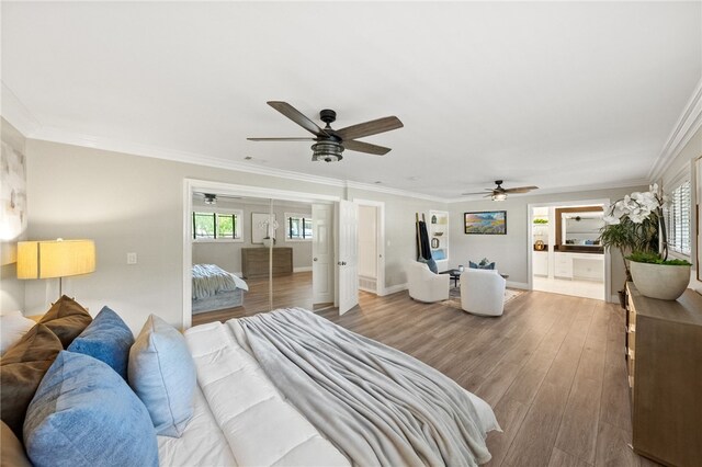 bedroom featuring wood-type flooring, connected bathroom, ceiling fan, and crown molding