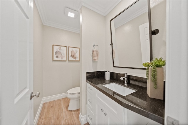 bathroom with crown molding, hardwood / wood-style floors, vanity, and toilet