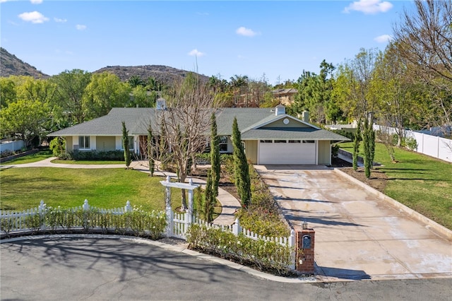 view of front of home with a garage, a mountain view, and a front yard