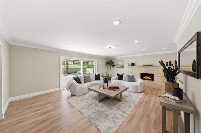 living room with a premium fireplace, ornamental molding, and light hardwood / wood-style floors