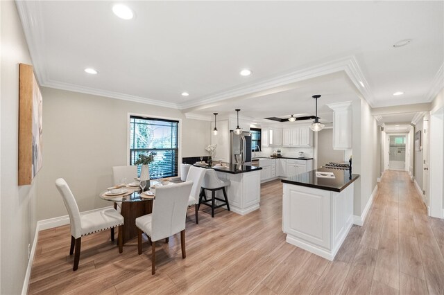 dining space featuring ornamental molding and light hardwood / wood-style floors