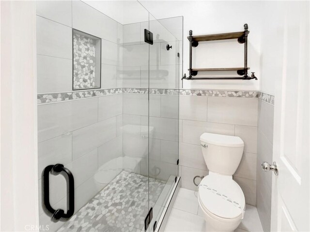 bathroom with walk in shower, a baseboard radiator, toilet, and tile walls